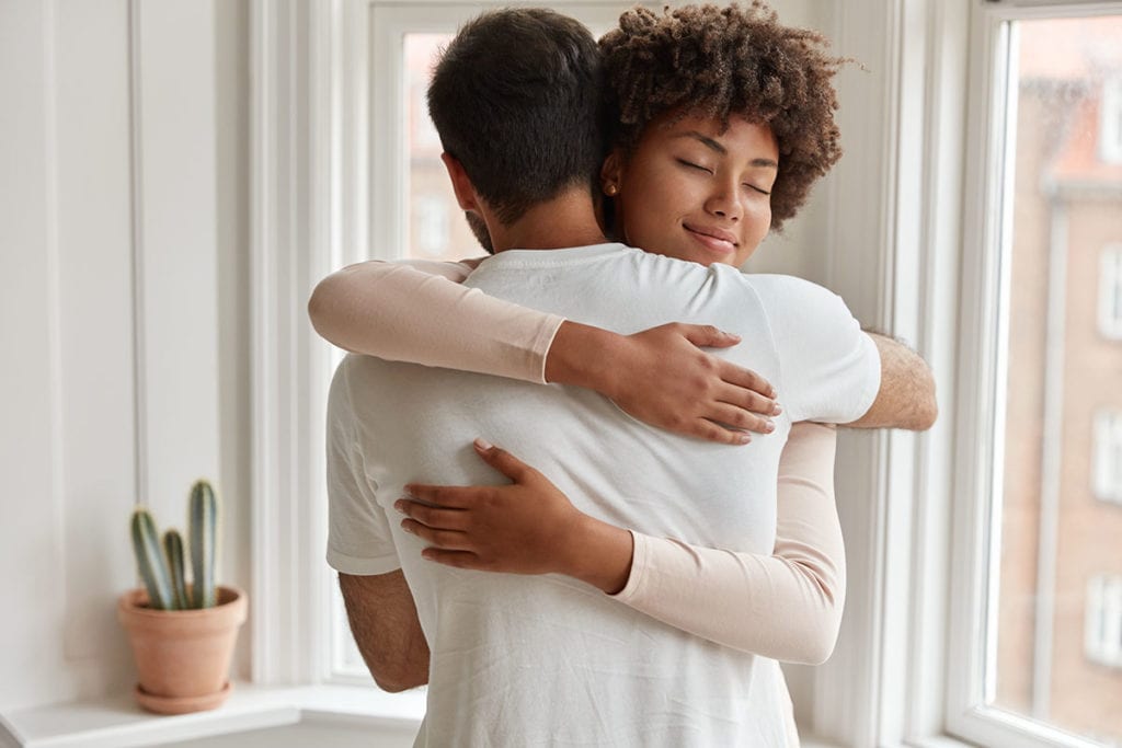 a woman hugs a man to comfort him after he asks am i an alcoholic