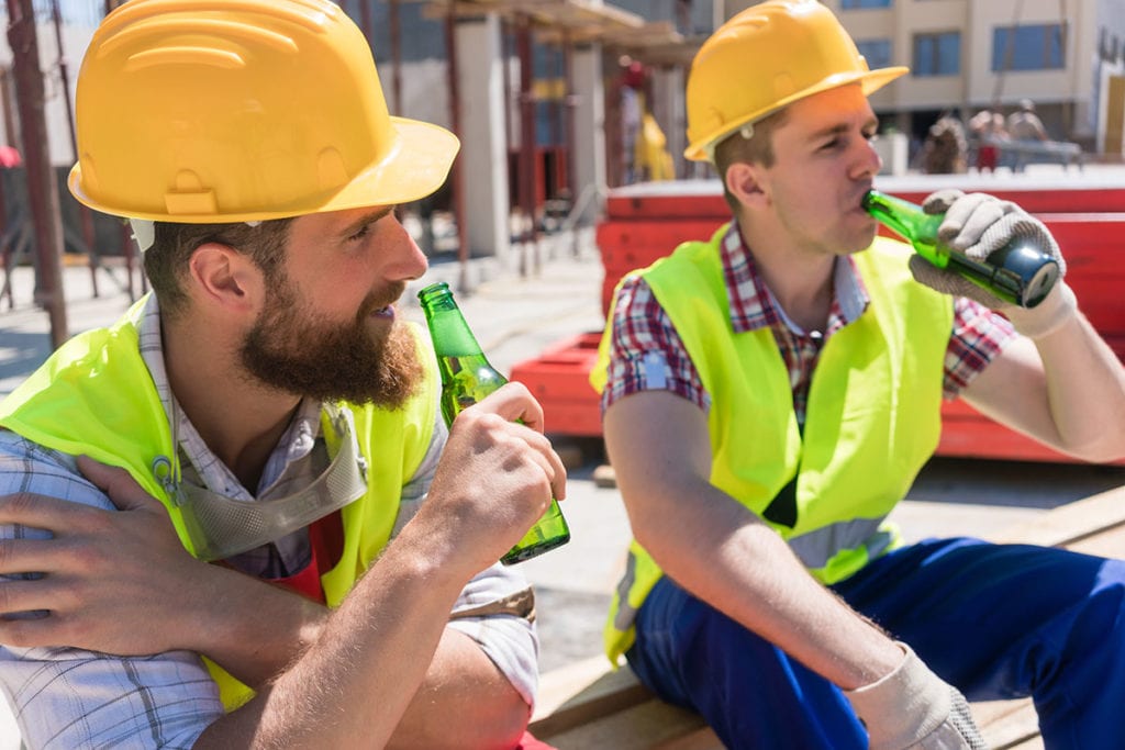 two construction workers drink and discuss the signs of a high functioning alcoholic