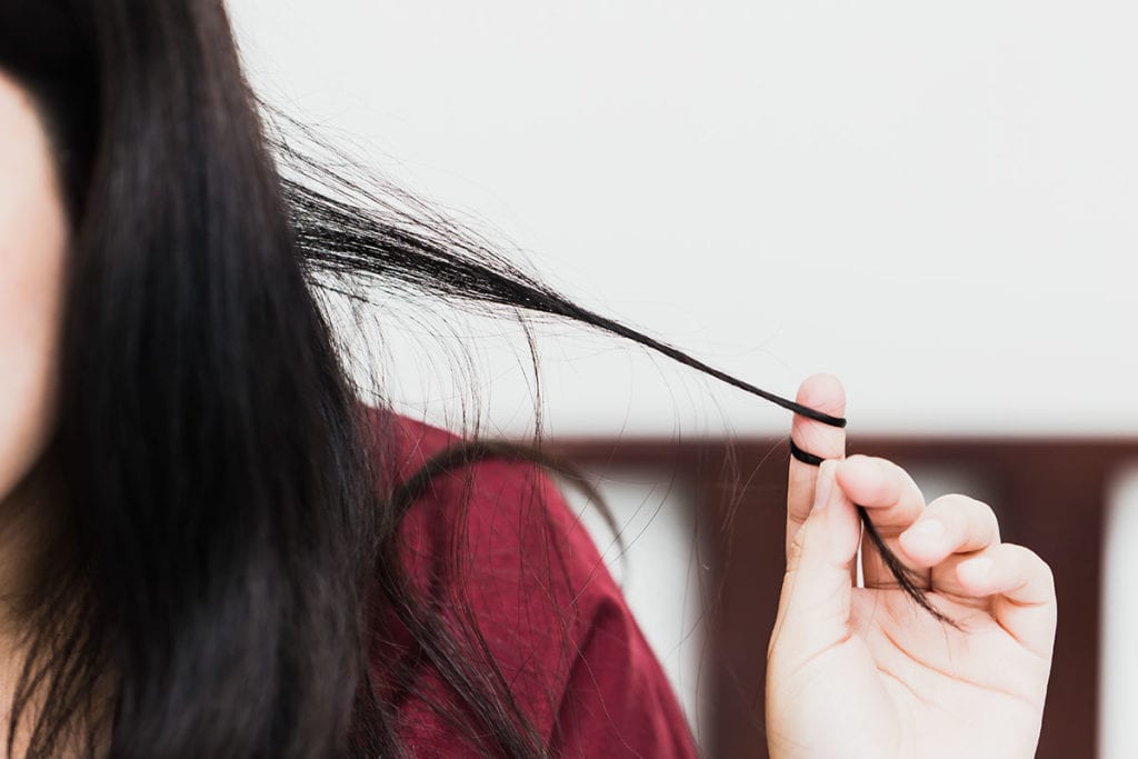 A young woman wraps her hair around her finger as she considers scrupulosity