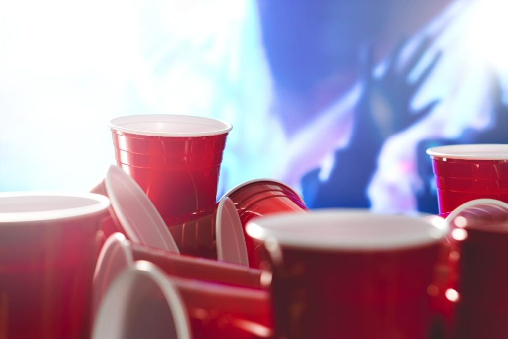 red cup full of alcohol are strewn about at a college party