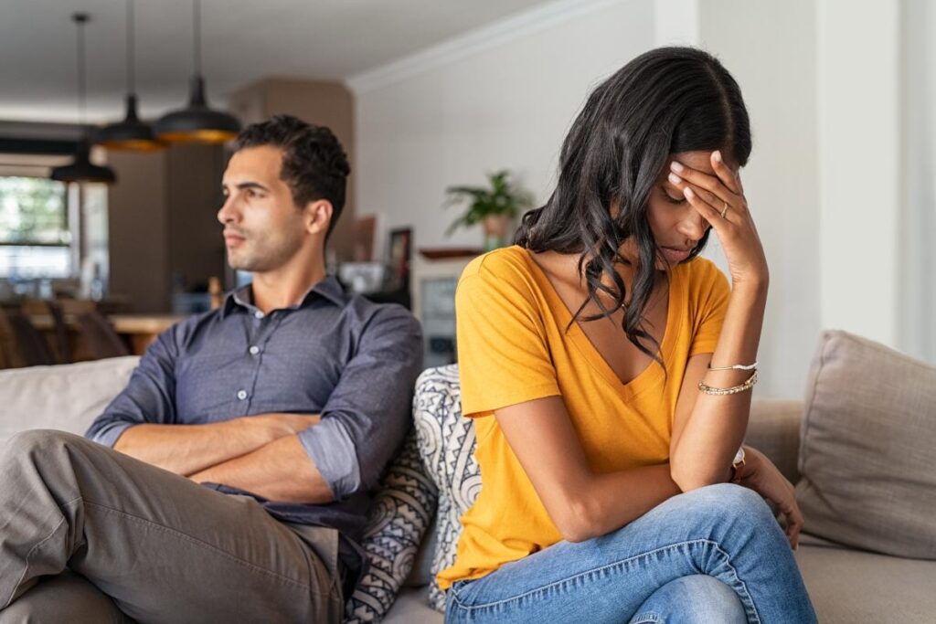 Couple on couch not getting along after learning about the signs your partner is a sex addict