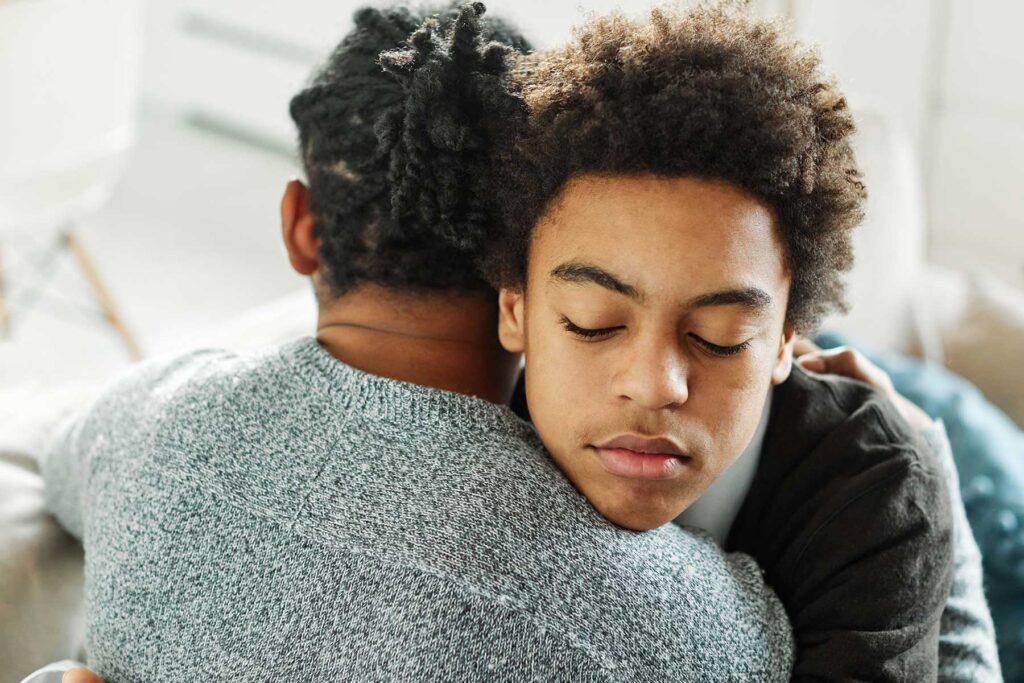 Person learning how to forgive an alcoholic parent while hugging them