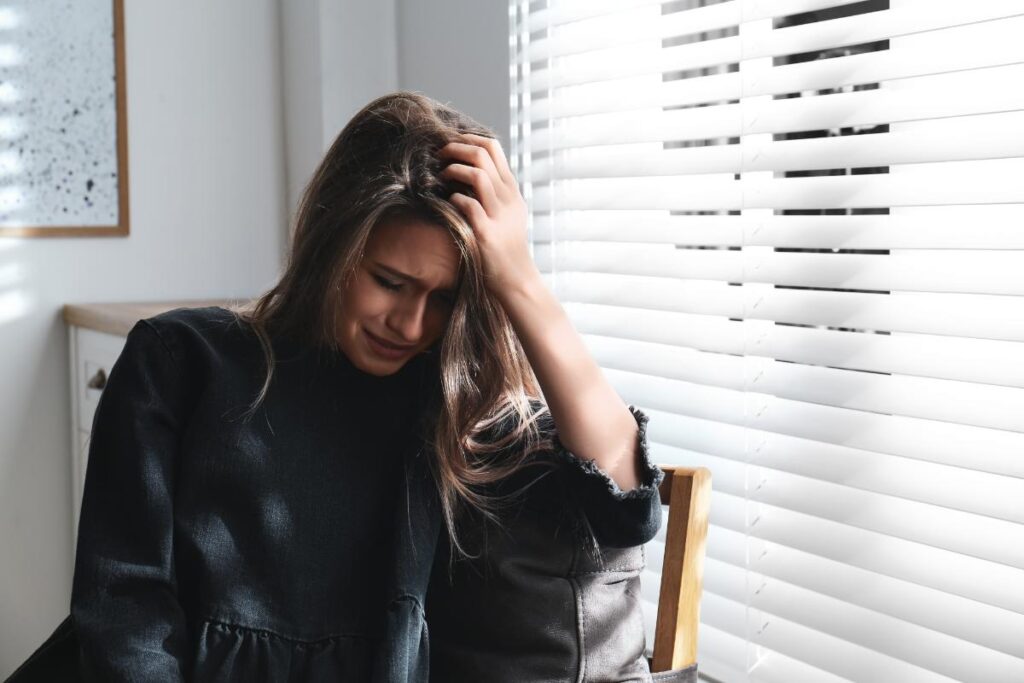 woman with head in hand considering major depression in women