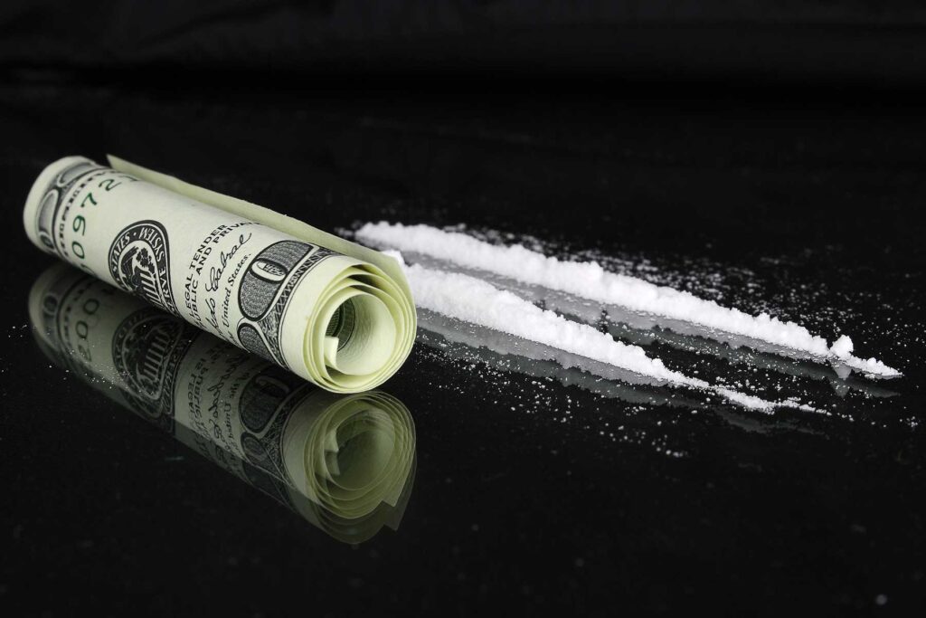 "What makes cocaine addictive?"—someone may wonder as they look at these lines of cocaine and a rolled-up dollar bill
