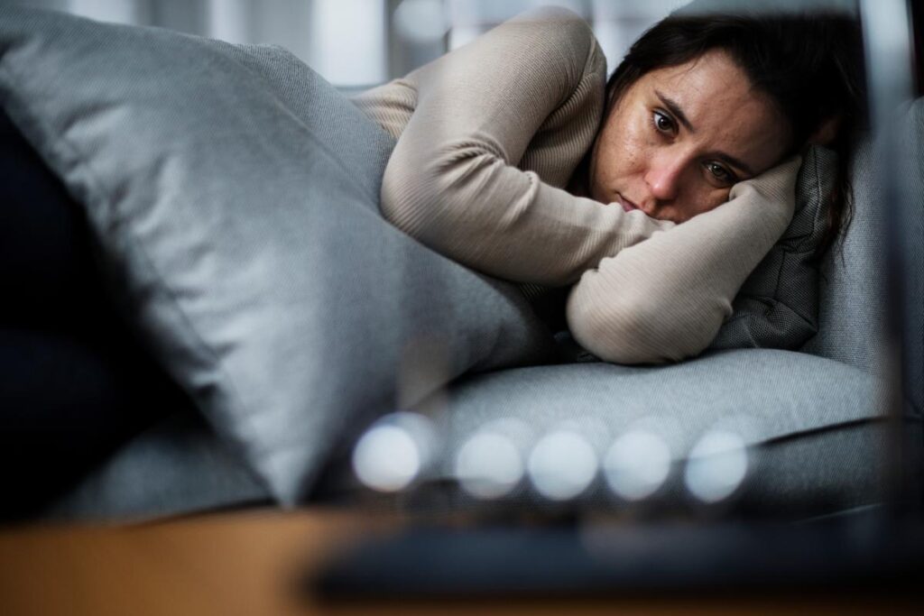 a person in bed looks tired after struggling with alcohol withdrawal and night sweats