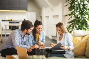 couple talks to businesswoman with portfolio about aetna rehab insurance coverage