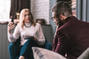 female therapist talks to male patient in an alcohol addiction treatment center