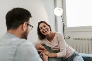 woman smiles while being comforted by a man in a meth detox center