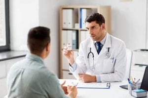 doctor showing patient prescription at painkiller addiction treatment center