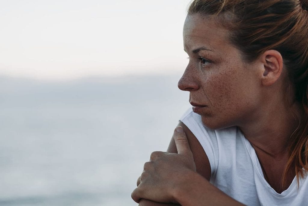woman looking out over ocean going through the 5 stages of addiction