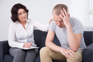 a man with his therapist discussing rational emotive behavioral therapy programs