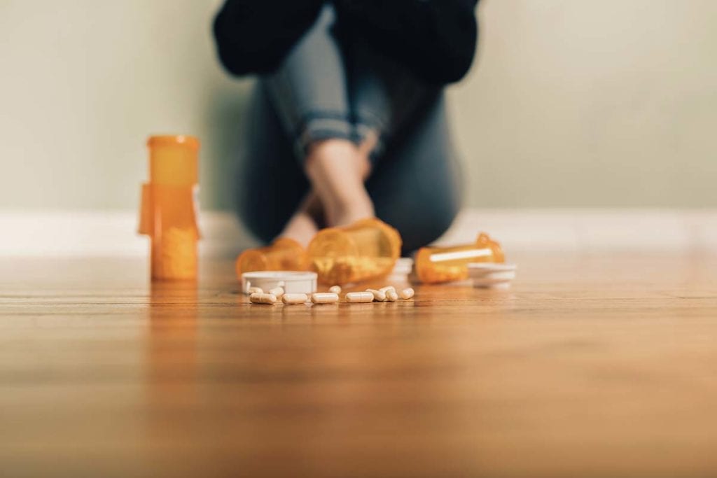 opioid addict on the floor with opioids know she is part of the opioid epidemic statistics