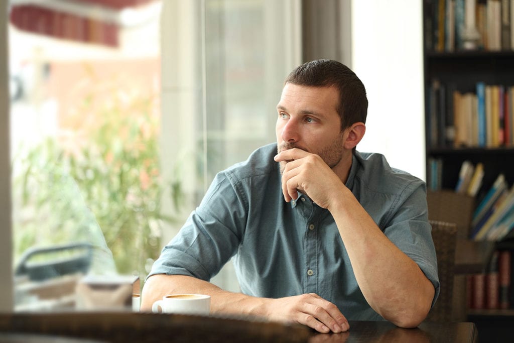 a man sits in a coffeeshop and thinks about the addiction definition