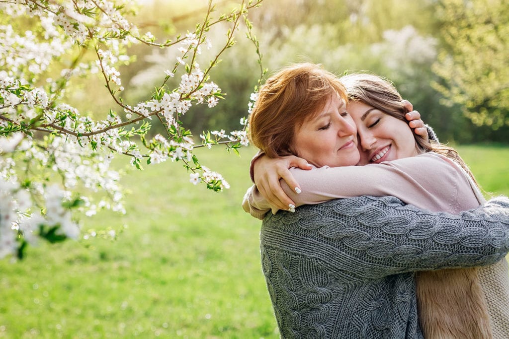 a mother and daughter hug each other after talking about how to live with a loved one in recovery