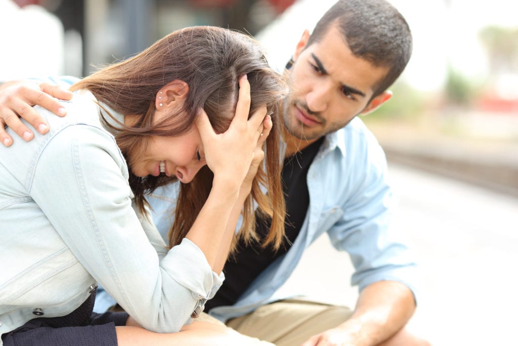 a man comforts a woman as he wonders is my loved one struggling with depression