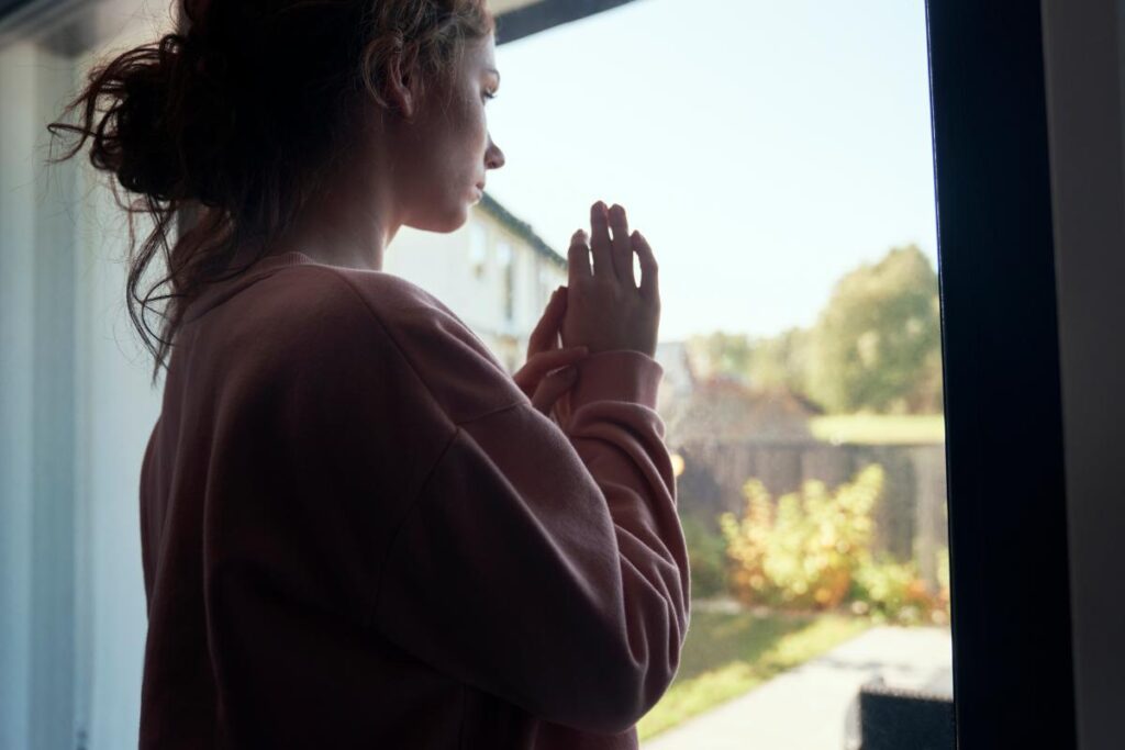 woman looking out the window considers physical vs psychological dependence