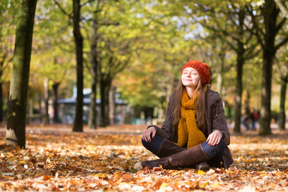 Woman in autumn meditating for mental health and mental rest