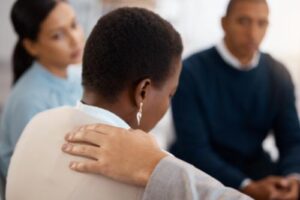 woman in drug addiction treatment centers being comforted by peer