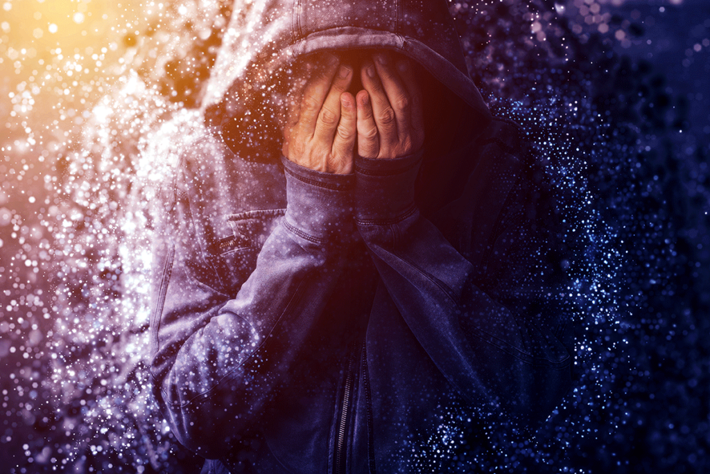 Woman in hoodie with hands covering her face while wondering what does a panic attack feel like