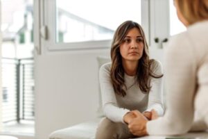 woman sitting on couch discusses a borderline personality disorder treatment program