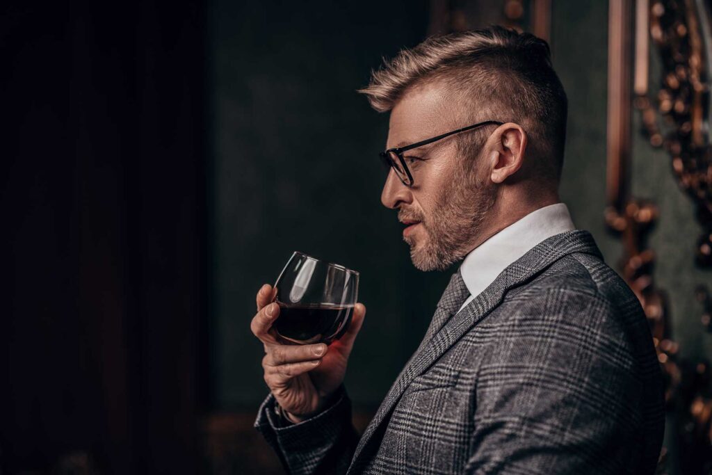 Man drinking at work and hoping none of his co-workers learn how to recognize a high-functioning alcoholic