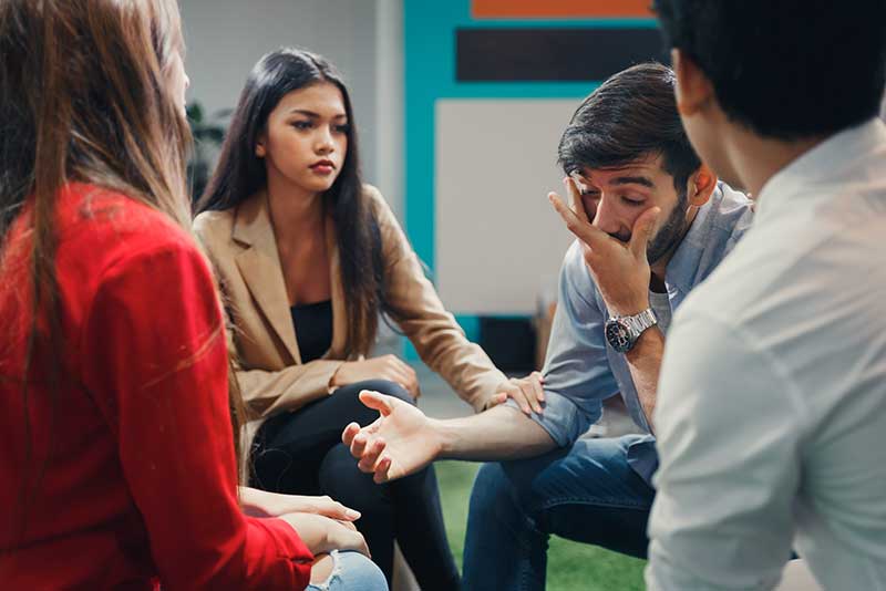 People supporting each other in group therapy at a meth addiction treatment center