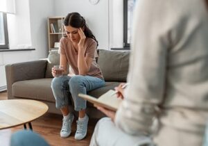 Client sits on couch and puts hands to face during a frustrating relapse prevention counseling session