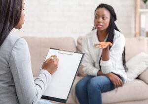 Client sits on couch and talks to health professional during stress management therapy program