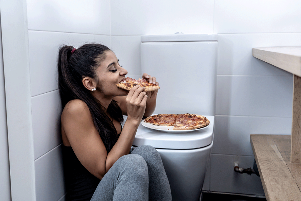 Woman binge eating and wondering, "Is binge eating equally common among men and women?"